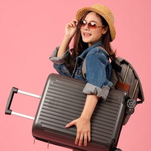 mulher com mala de viagem indicando o que levar na bagagem para cuidar dos cabelos